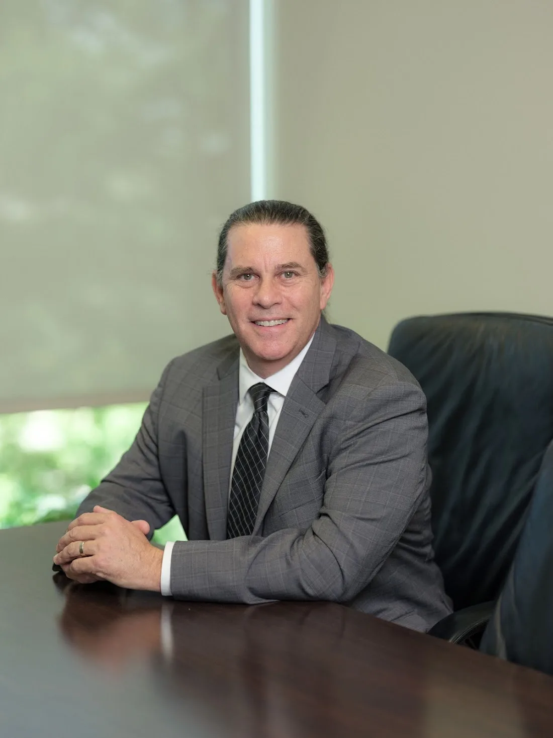 Kent Starr at his office desk, hands clasped, ready to listen to a new client's case.